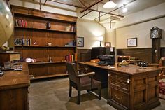 an old fashioned office with desk, chair and bookshelf in the middle of it