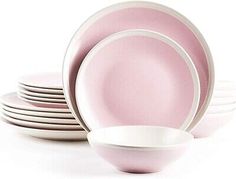 pink and white dishes stacked on top of each other in front of a white background