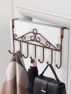 a coat rack with two coats hanging from it's sides and a purse on the other side