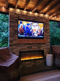 a flat screen tv mounted to the side of a brick wall above a fire place