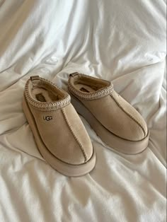 a pair of slippers sitting on top of a bed