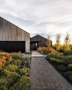 a house that is surrounded by plants and flowers