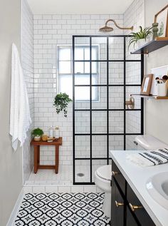 a white tiled bathroom with black and white tiles