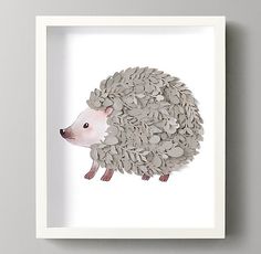 a hedgehog made out of coins in a white frame on a gray wall next to a plant