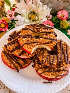 an apple slice with chocolate drizzled on top and sliced apples in the middle