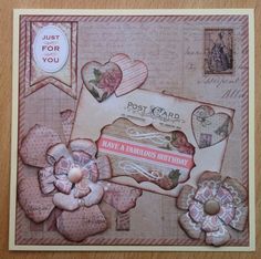 a close up of a greeting card with flowers and hearts on the front, surrounded by postcards