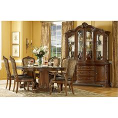 a dining room table with chairs and china cabinet