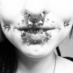 a woman with piercings on her face and nose