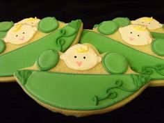 three decorated cookies sitting on top of each other in the shape of peas and babies