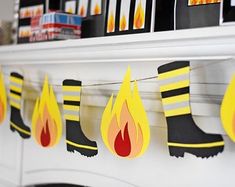 a fireman's boot and boots are hanging from a mantle with paper decorations