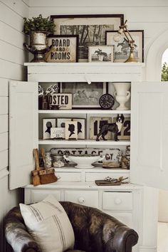 a chair sitting in front of a white book shelf filled with pictures and other items