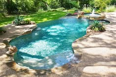 an outdoor swimming pool in the middle of a yard with trees and bushes around it