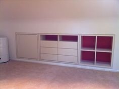 an empty room with white and red shelving unit