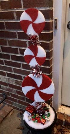 candy canes are stacked on top of each other in front of a brick wall