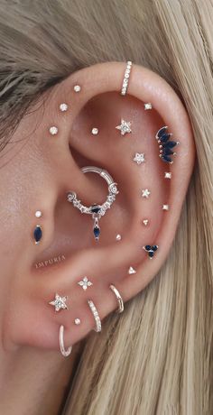 an ear with several different piercings on top of it and one is in the shape of a star