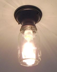 a mason jar light fixture on a white ceiling