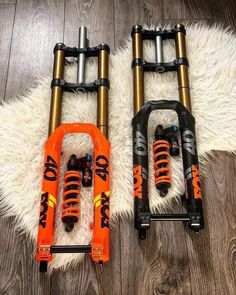 two orange and black bike pedals laying on top of a white rug next to each other