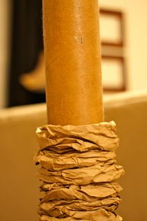 a close up of a brown paper wrapped around a wooden pole in a living room