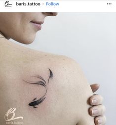 a woman with a tattoo on her shoulder holding onto the back of her left arm