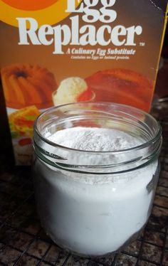 a glass jar filled with white powder next to a box of egg replacer on a table