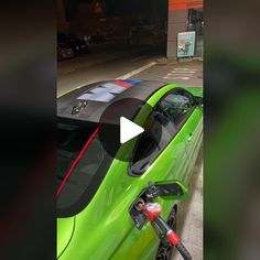 a green car parked in front of a gas station with an electric charger attached to it