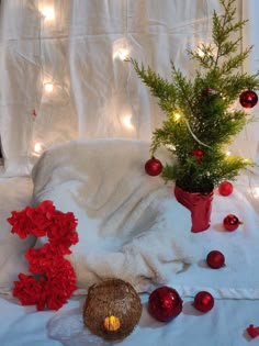 christmas decorations and candles on a bed with white sheets