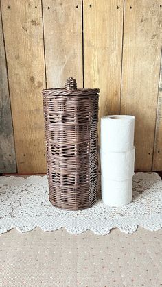 two rolls of toilet paper sitting next to each other on a doily covered table