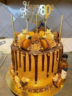 a birthday cake with chocolate icing and decorations on top is sitting on a table