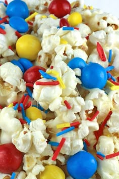 popcorn with red, white and blue candies on top is shown in close up