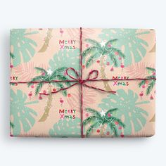 a wrapped present with palm trees and merry christmas lettering