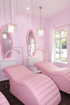 a room with pink furniture and mirrors in it