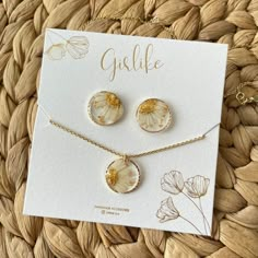 three pieces of jewelry sitting on top of a card next to a flower necklace and earring