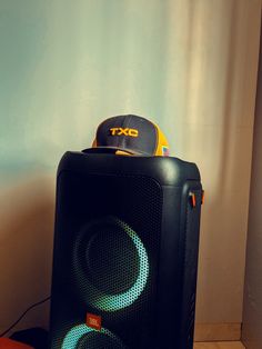 a speaker sitting on top of a table next to a hat