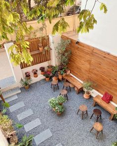 an overhead view of a patio with potted plants and wooden benches in the middle