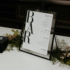 a table with a sign and flowers on it