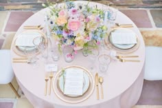 the table is set with flowers and place settings