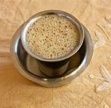 a metal cup filled with liquid on top of a table