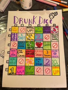 a poster with the words drunk dice written in different colors on it next to pencils and markers