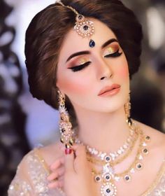 a woman with makeup and jewelry on her face