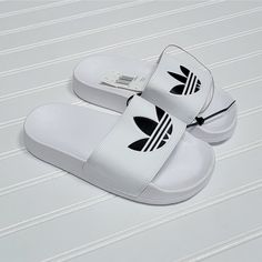 Nwt Adidas Adilette Lite Slides/Sandals, Size 3 Big Kid, White With Black Logo, White Synthetic Slip-on Slippers, Trendy White Beach Slippers, Casual White Slip-on Flip Flops, Adidas Non-slip Flat Slides, Casual White Slip-on Sport Sandals, Trendy White Vacation Slippers, White Non-slip Sport Sandals For Beach, Non-slip White Sport Sandals For The Beach, White Non-slip Slides For The Beach