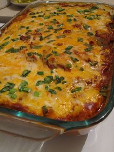 a casserole dish with meat and cheese in it sitting on a stove top