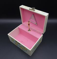 an open pink and white box with a figure inside