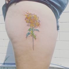 a sunflower tattoo on the back of a woman's thigh