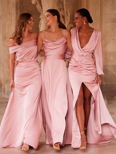 three beautiful women in pink dresses standing next to each other and smiling at the camera