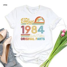 Retro 40th Birthday Tee, Born in 1984, Vintage 1984 Tshirt, 40th Birthday Gift Women, 40 Years Birthday Shirt, 1984 Birthday Limited Edition ----- How To Order ----- 1-) Please, check and review all the photos. 2-) Choose your t-shirt size and color. *Different styles of shirts may have different shades of same color choice due to different manufacturer brands. *For this reason, we recommend you to match shirts from the same styles if you want precisely matching colors (ex. Unisex, V-necks, Todd Vintage 1984 Shirt, 1984 Birthday, 1984 Shirt, Birthday Tee, 40th Birthday Gifts, Matching Colors, Kids Graphic Tees, Shirt Fits, Birthday Gifts For Women