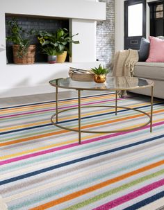 a living room filled with furniture and a colorful rug on top of a carpeted floor