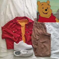 a winnie the pooh shirt, jeans and sneakers are laying on a white sheet