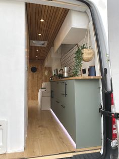 the back door of a van is open to reveal a kitchen and living room area