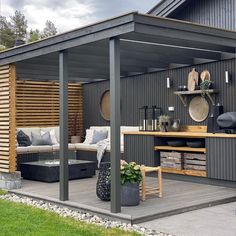 an outdoor living area is shown in the backyard with wooden walls and gray sidings