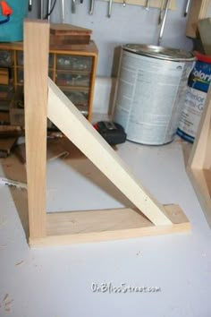 a wooden triangle sitting on top of a table next to some tools and other items